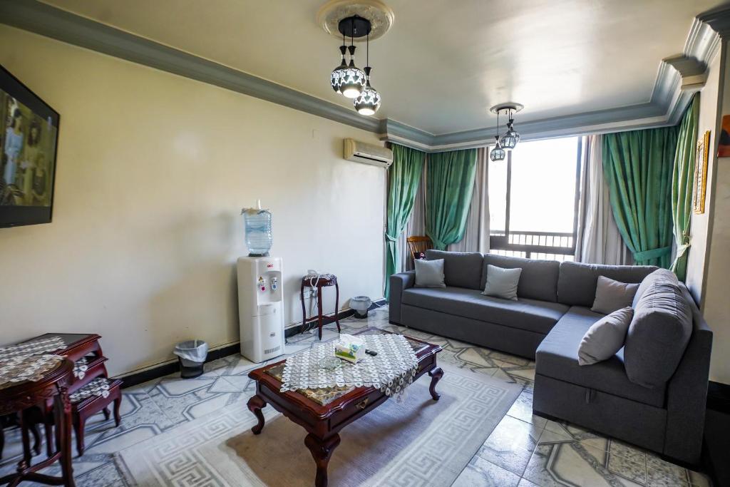 a living room with a couch and a table at Spacious flat 7 mins to Airport in Cairo