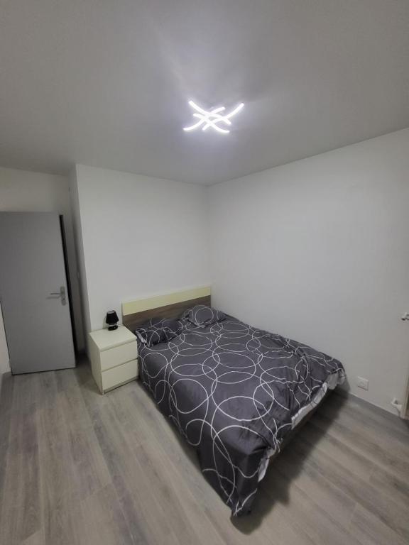 a bedroom with a bed with a black comforter at Chambre Neuve dans un logement partagé in Allonnes