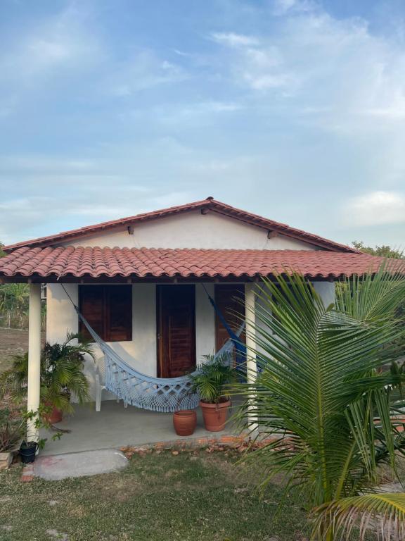 ein kleines weißes Haus mit Pflanzen davor in der Unterkunft Sítio Paraíso do Caju in Barreirinhas