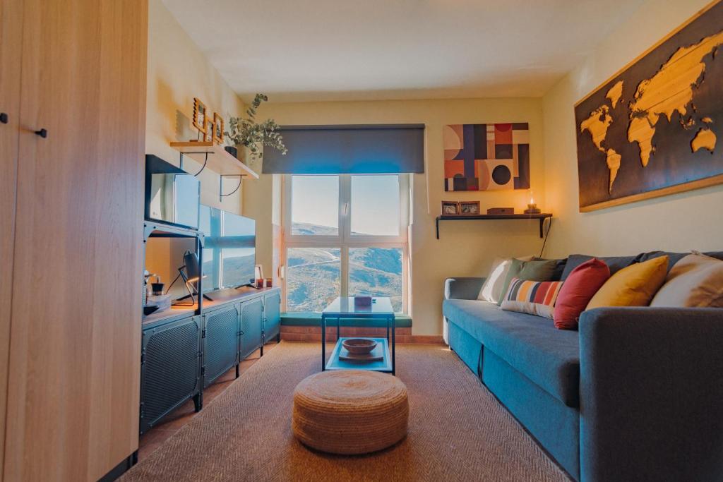 - un salon avec un canapé bleu et une table dans l'établissement Alpine Home Sierra Nevada, à Sierra Nevada