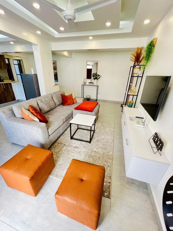 a living room with a couch and a tv at Nyali Luxury Apartments Mombasa AJ STAYS in Mombasa