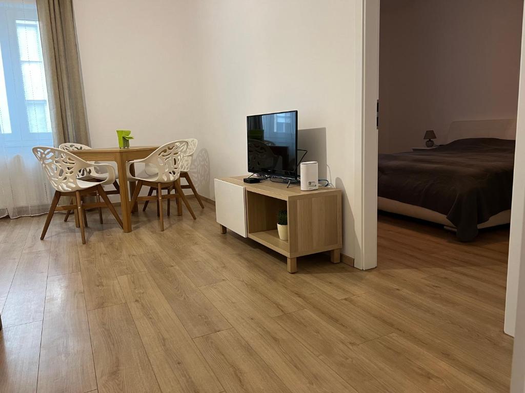 ein Wohnzimmer mit einem TV und einem Tisch mit Stühlen in der Unterkunft Wohnung 1210 in Wien