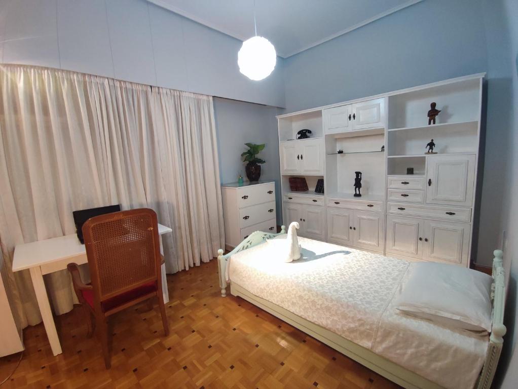 a bedroom with a bed and a desk in it at Charm & Comfort near Petralona station in Athens