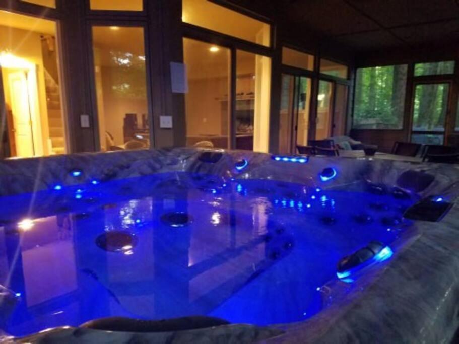 a jacuzzi tub in a room with blue lights at Woodshores Retreat - cozy retreat, hot tub, Lk MI in Coloma
