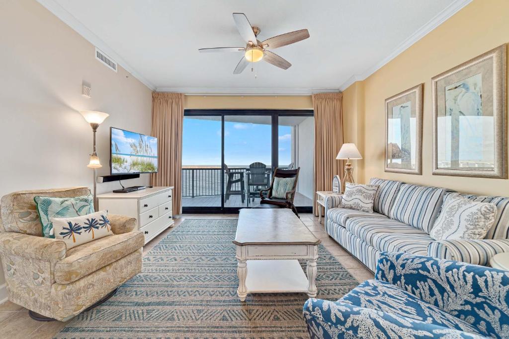 a living room with a couch and a tv at Grand Pointe Unit 303 in Orange Beach