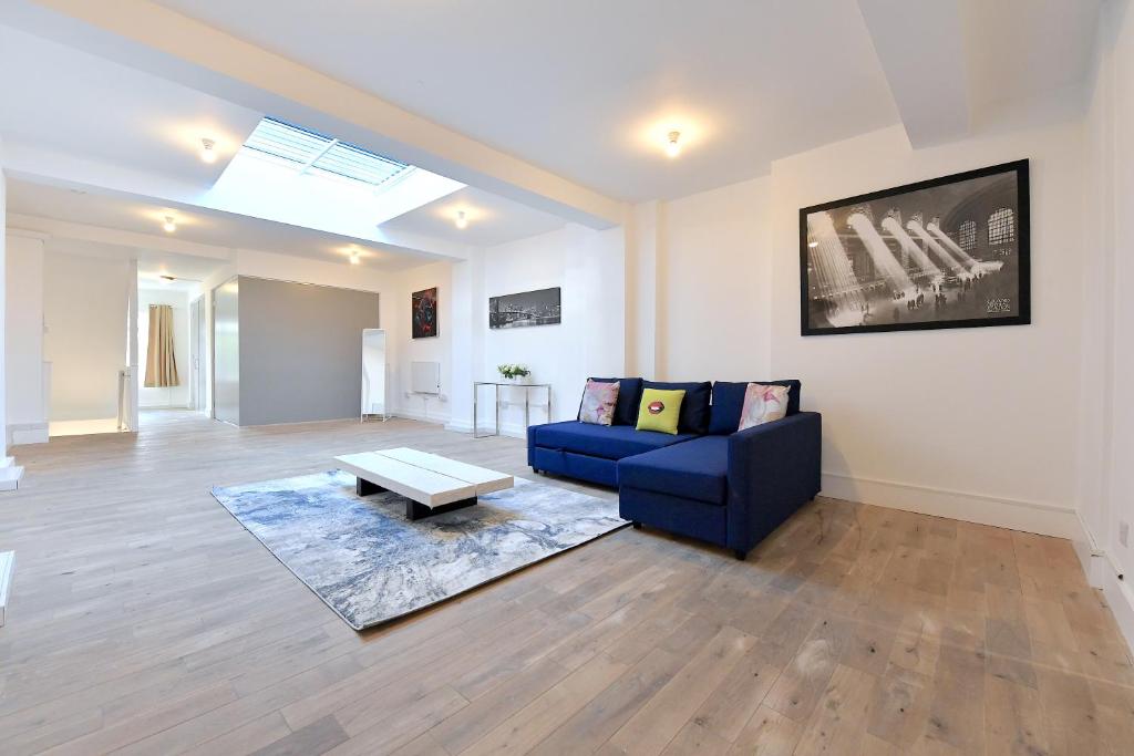 - un salon avec un canapé bleu et une table basse dans l'établissement Fabulous duplex apartment in Dalston Junction, à Londres