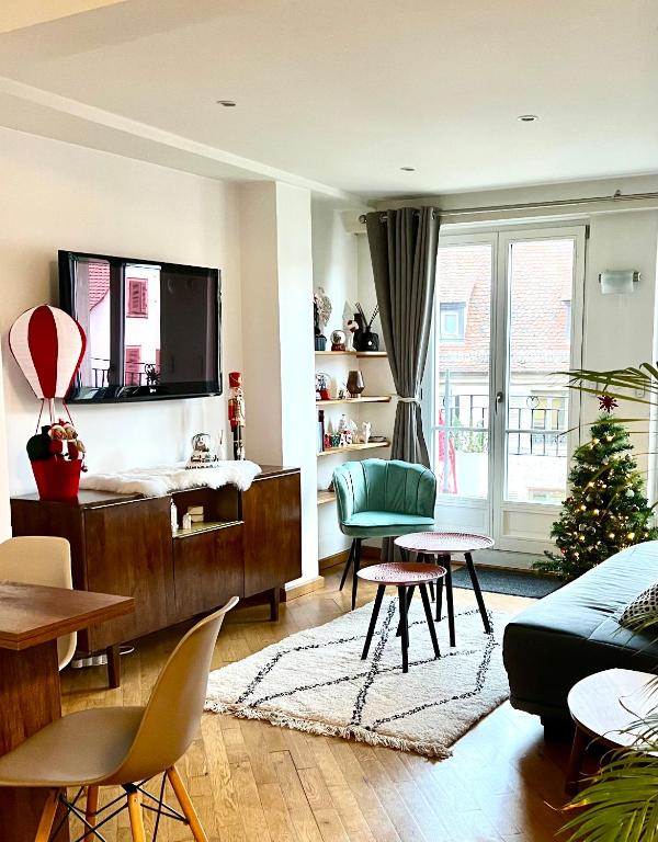 un salon avec une télévision et un arbre de Noël dans l'établissement Magnifique Appartement 4 personnes - 2 Chambres - 2 SdB - Grande Terrasse Rue des Têtes - Colmar Centre, à Colmar