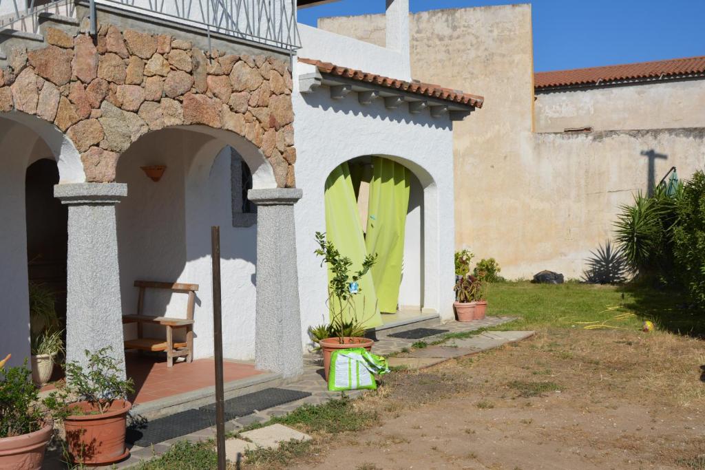 ein Haus mit einem grünen Surfbrett in der Tür in der Unterkunft Giardini Di Fraicu in Arzachena