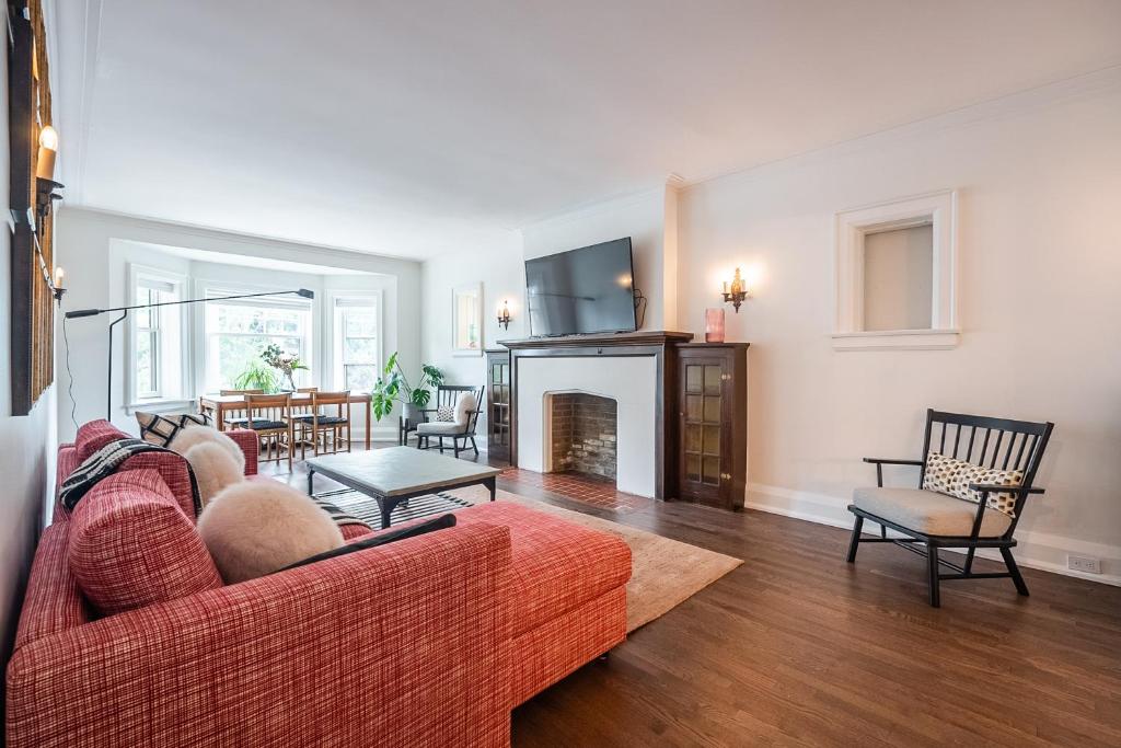 Beautiful and Spacious Luxury Home في تورونتو: غرفة معيشة مع أريكة حمراء ومدفأة