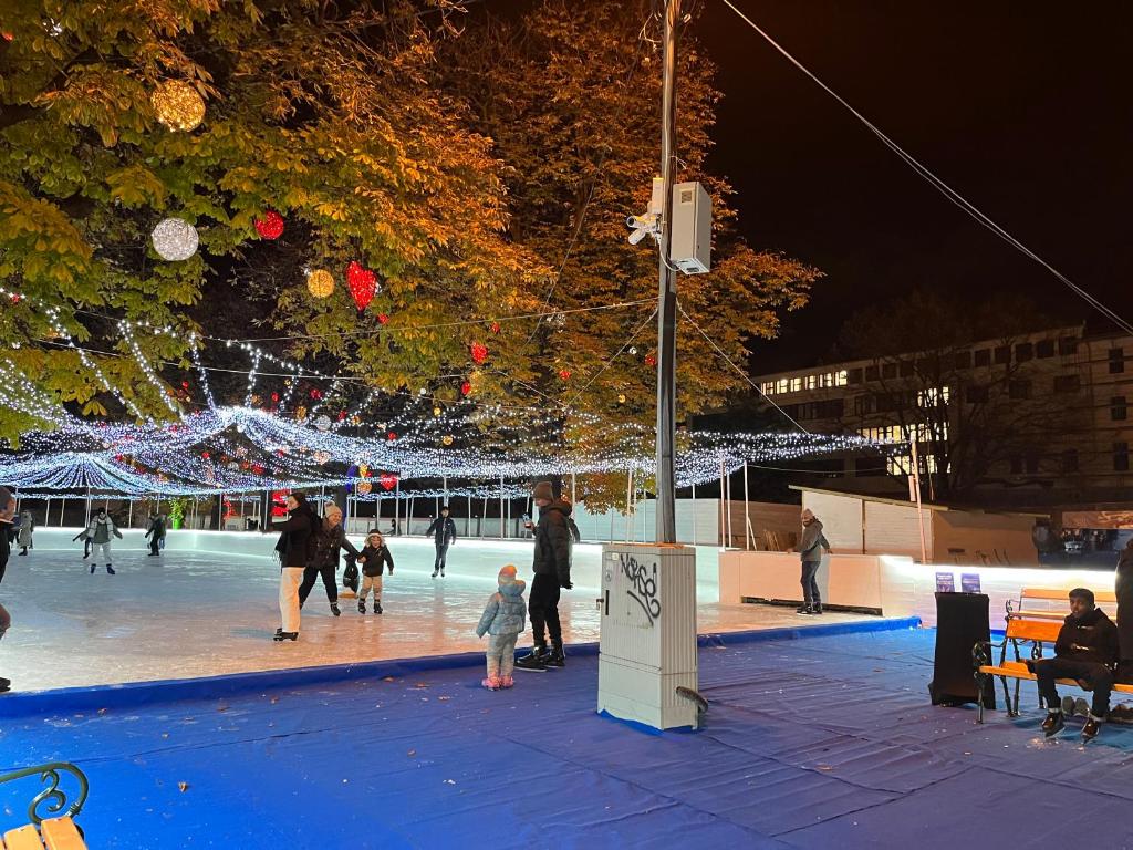 un grupo de personas caminando por una pista de hielo por la noche en Comebackpackers, en Budapest