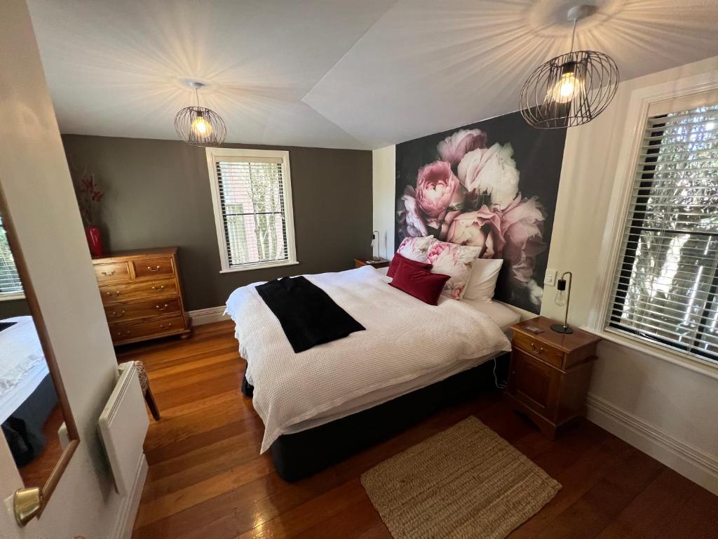 um quarto com uma cama grande e uma pintura na parede em Pinot Villas em Martinborough