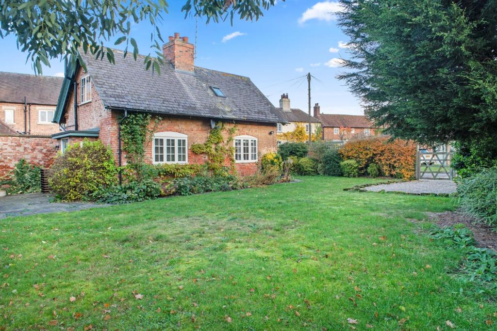 una casa de ladrillo con un patio delante de ella en Beautiful 2 Bedroom Cottage in Oxton, en Oxton
