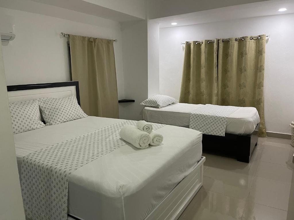 sypialnia z 2 łóżkami i ręcznikami w obiekcie Plataview Apartahotel apt 4A w mieście Monte Plata
