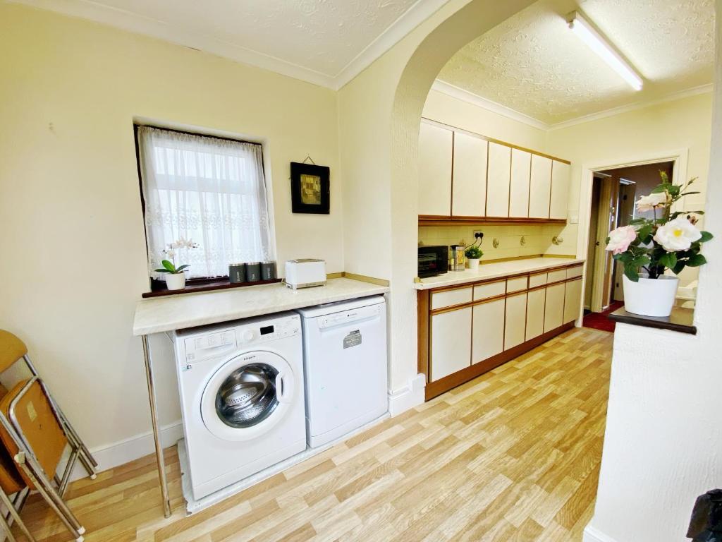 a kitchen with a washer and dryer in a room at Barking London House sleeps 12 - parking - train tube - airport in London