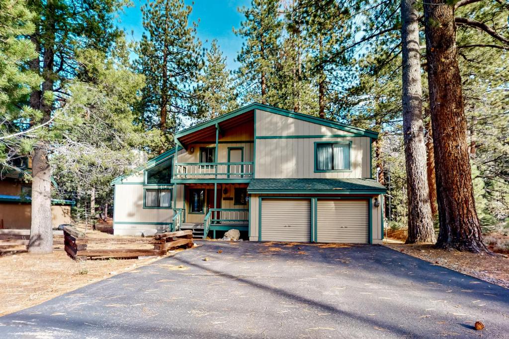 a house with a garage in the woods at Antler & Pine in South Lake Tahoe