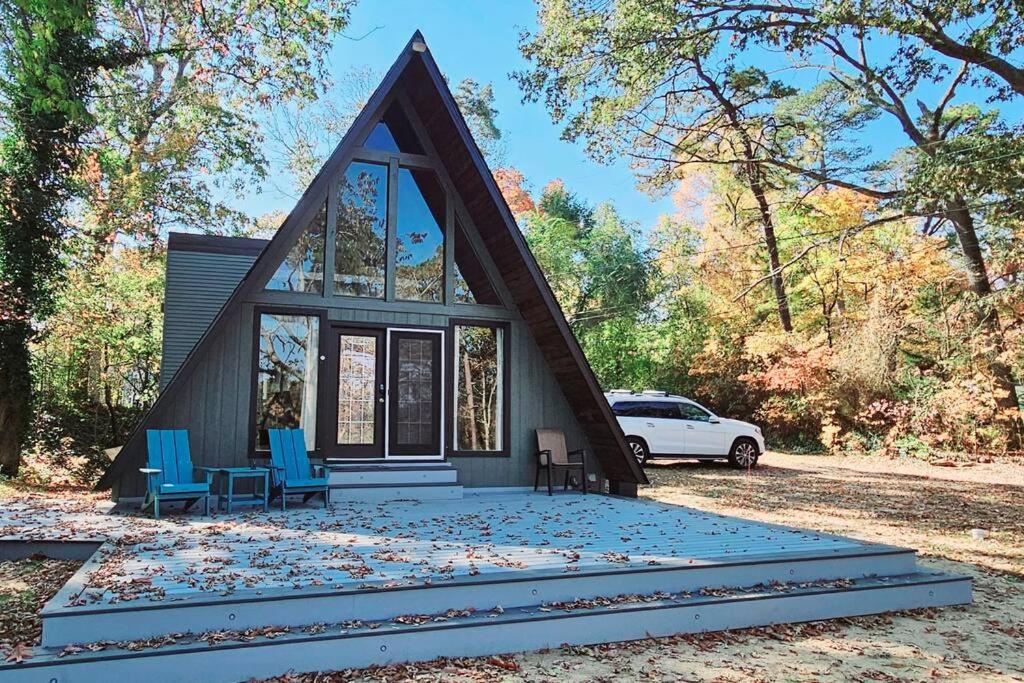 a small house with a triangular roof and blue chairs at NJ Lakefront A-Frame, Millville, NJ - 2 bedroom Cabin Home in Millville