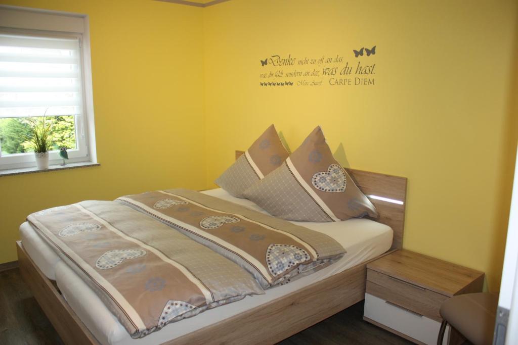 ein Schlafzimmer mit einem Bett mit einem Schild an der Wand in der Unterkunft Gaestehaus Bachmann in Dutenhofen