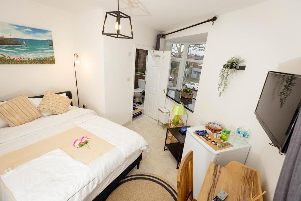1 dormitorio con 1 cama y TV. en Airstaybnb en Mánchester