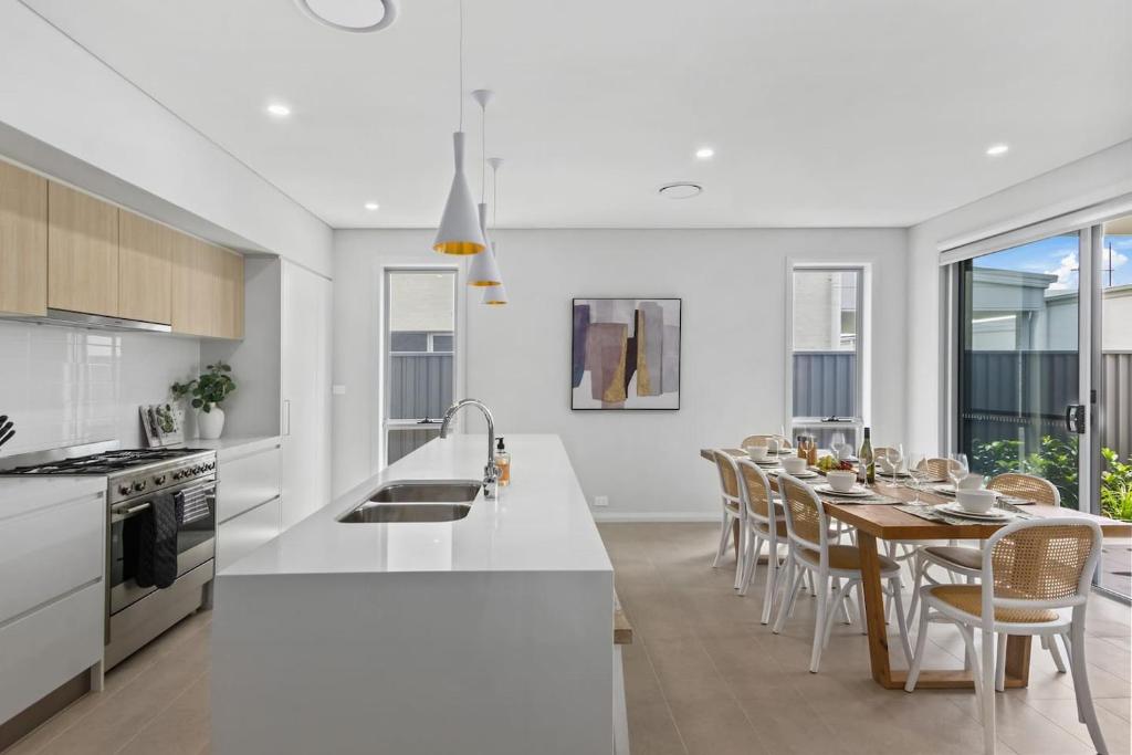 une cuisine et une salle à manger avec une table et des chaises dans l'établissement Marina Escape - Contemporary Coastal Living, à Shellharbour