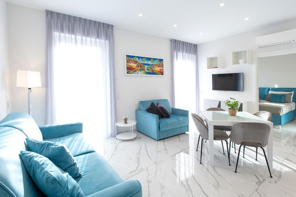 sala de estar con sofá azul y mesa en Tema Suites, en Nápoles