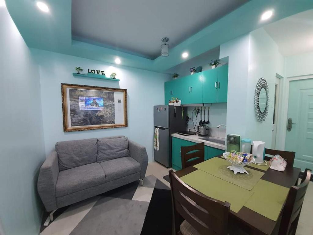 a kitchen and a living room with a table and a couch at Mistow Saekyung Condo in Lapu Lapu City