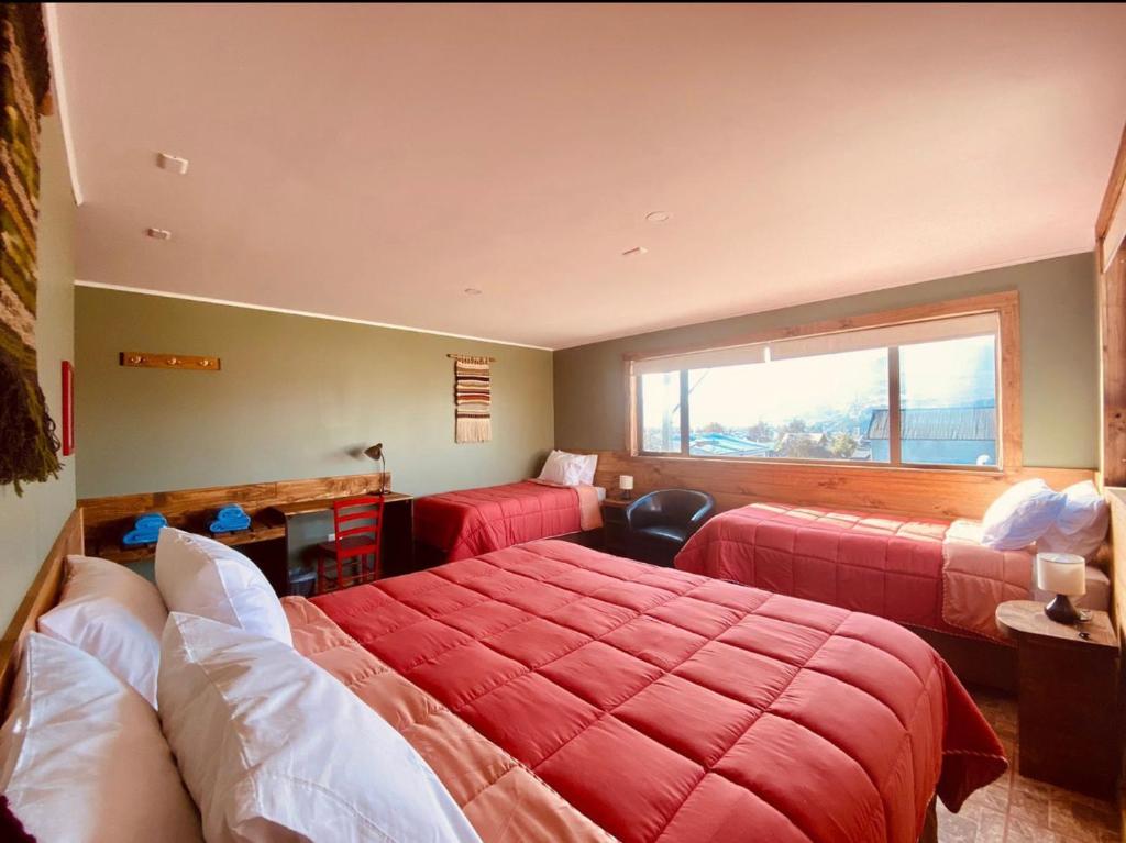 a hotel room with two beds and a window at Esquina Huella Patagónica in Coihaique