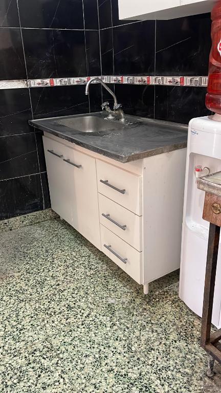 a kitchen counter with a sink and a refrigerator at Casona in Laferrere