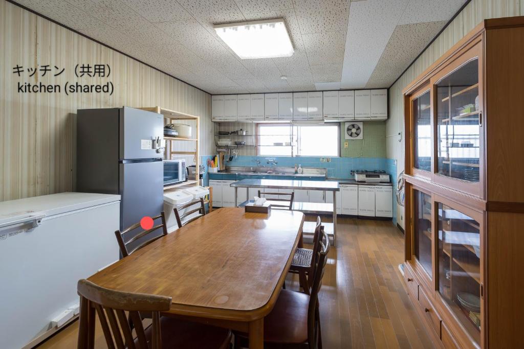 a kitchen with a wooden table and a refrigerator at 深山邸miyama-tei in Zentsuji