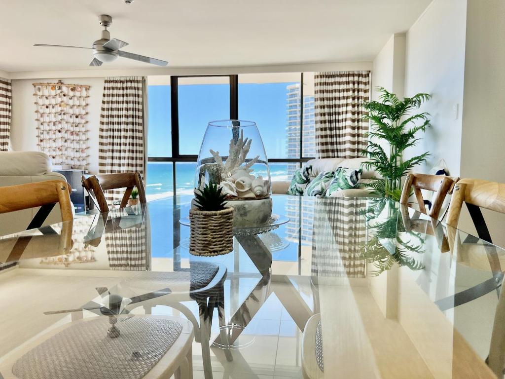 a living room with a glass table with plants on it at Seacrest, Surfers Beach Front 15A in Gold Coast