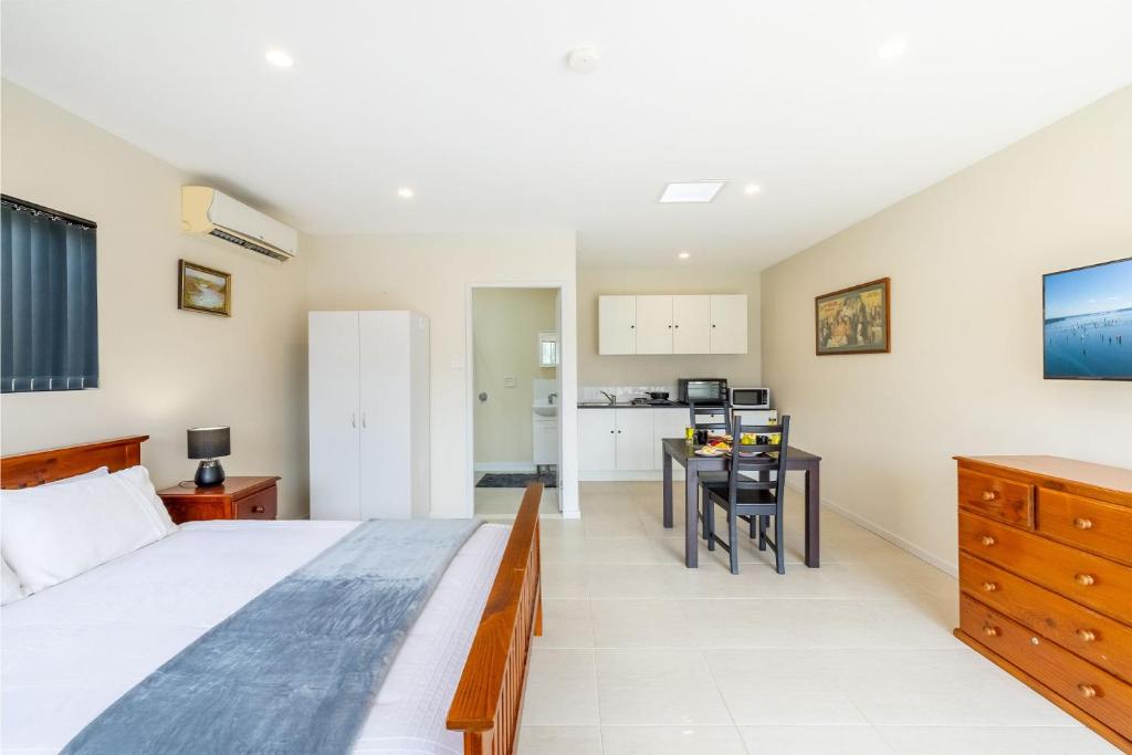 1 dormitorio con 1 cama grande y 1 mesa en 14A Grafton St - Pet friendly air con studio for a couples retreat, en Nelson Bay