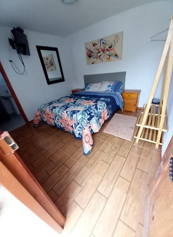 een slaapkamer met een bed en een houten vloer bij mini apartamento in Coquimbo