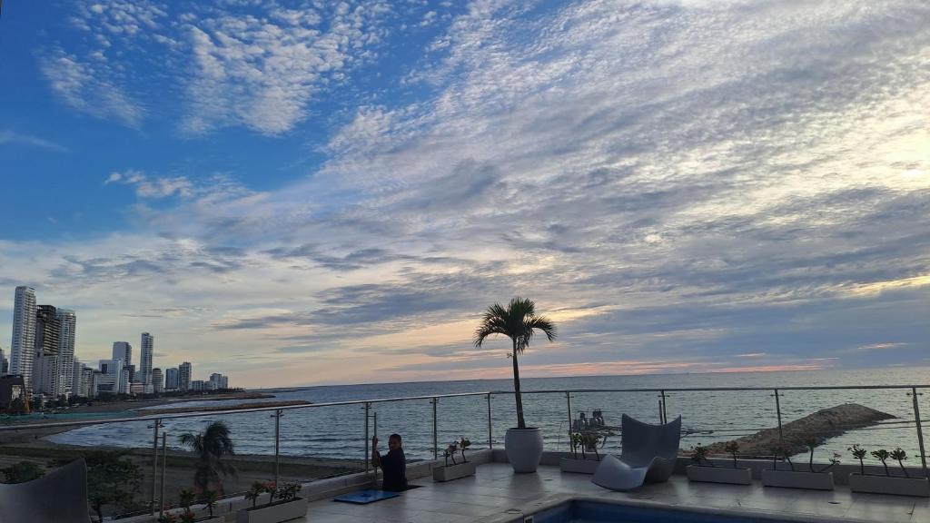 a view of the ocean from a resort with a palm tree at Apartamento Luxury frente al mar in Cartagena de Indias