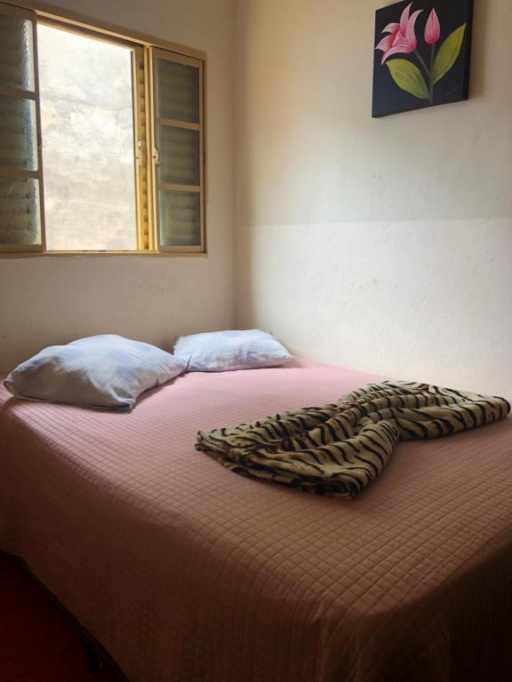 łóżko z kocem lamparta na górze w obiekcie Casa central stl w mieście São Thomé das Letras