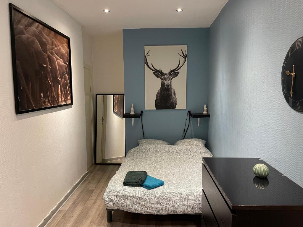 a bedroom with a bed with a deer head on the wall at 010 CHIC & COSY F1 29m2 HYPERCENTRE WIFI SMART TV NETFLIX in Saint-Étienne