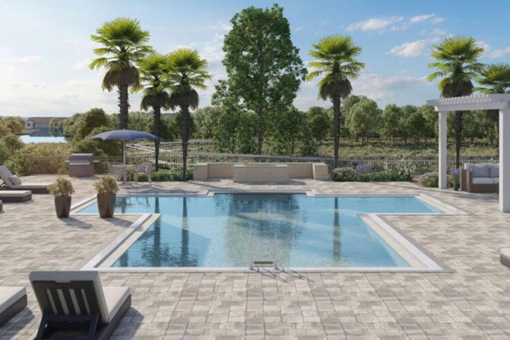 una piscina con palme sullo sfondo di 1BD/1BA Resort-Style Haven in Orlando, FL a Orlando