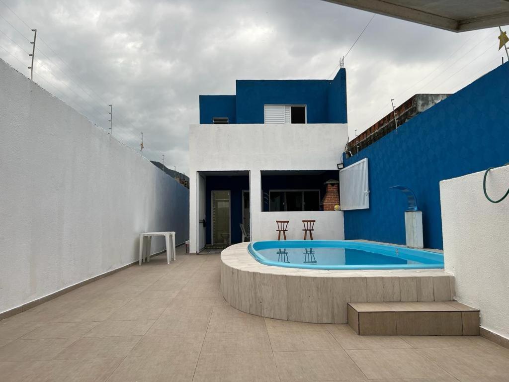 um edifício azul e branco com piscina em Casa temporada em peruibe em Peruíbe