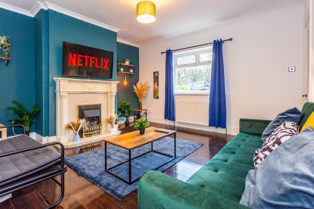 a living room with a green couch and a fireplace at Millway Apartments Newcastle Gateshead with Free Parking in Sheriff Hill