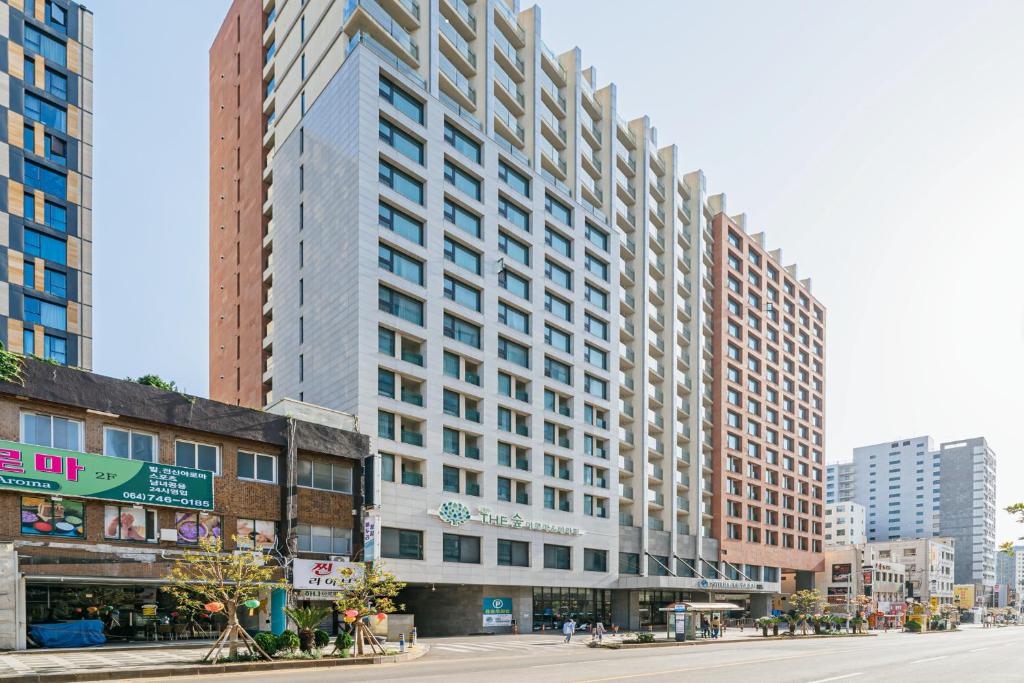 un edificio alto en una calle de la ciudad con edificios en Air City Hotel Corp en Jeju