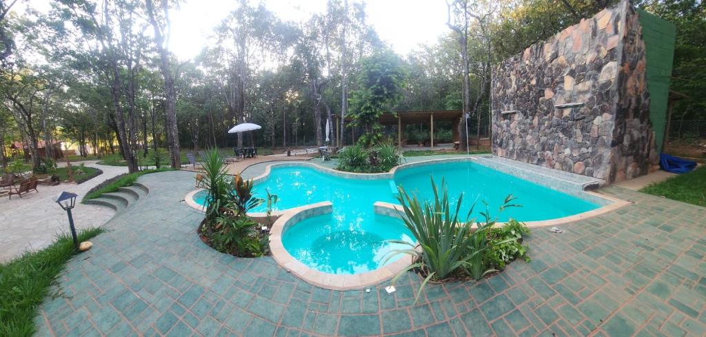 a swimming pool in a yard with a stone building at Casa Amarela in Pirenópolis