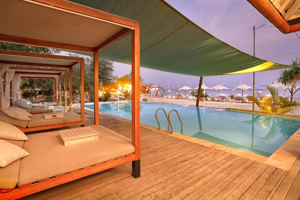 un complejo con piscina y cama con dosel en Gili Eco Villas, en Gili Trawangan
