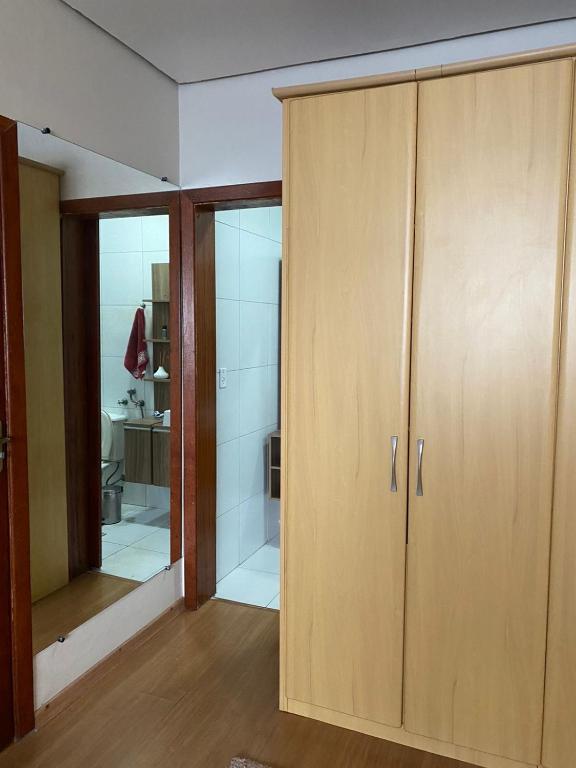 a room with a wooden cabinet and a mirror at Quarto em Casa na rua mais linda da Cidade in Rio Grande