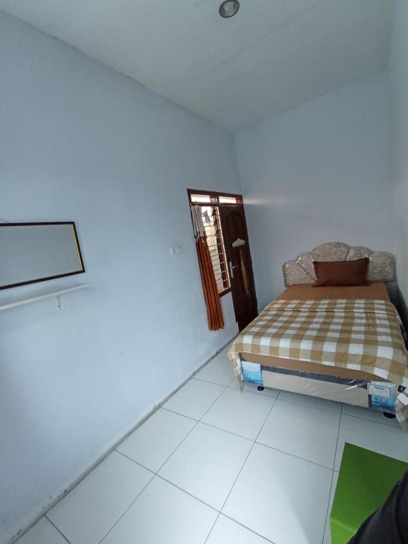 a bedroom with a bed in a white room at Villa Lilly in Batu