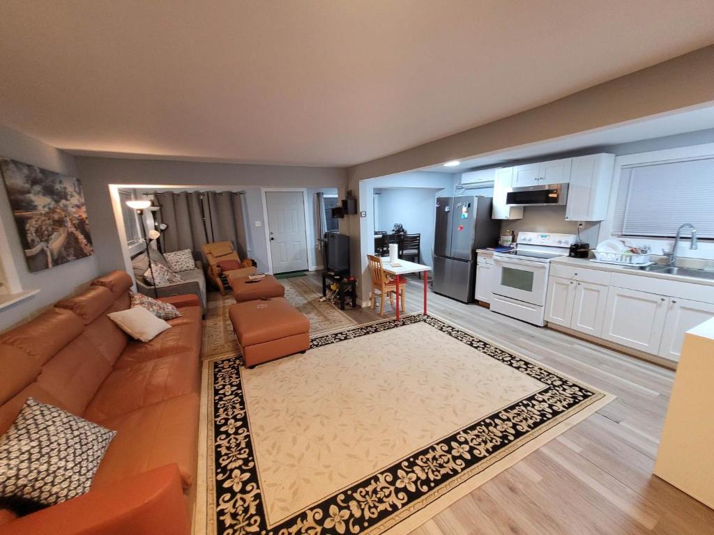 a living room with a couch and a kitchen at The Dune Beach House in Norfolk