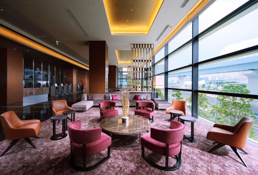 a lobby with a table and chairs and windows at Villa Fontaine Grand Tokyo Ariake in Tokyo