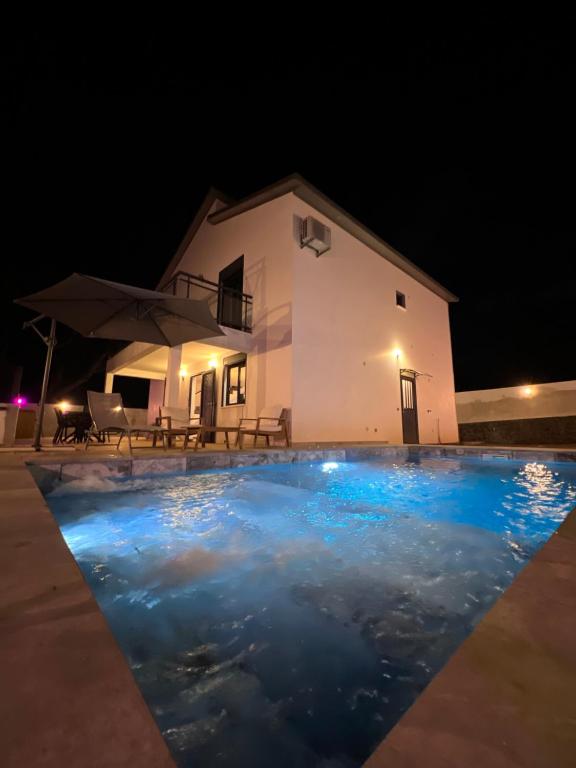 a building with a swimming pool at night at Villa Moderne et Piscine Privée in Saint-Pierre