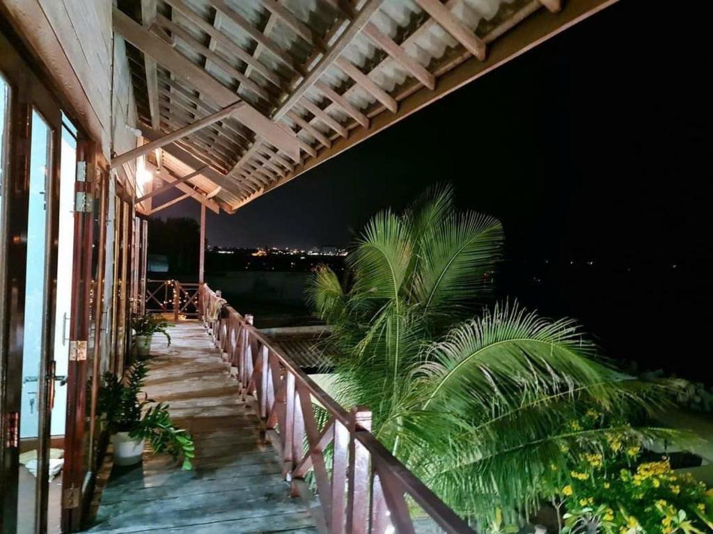 un balcón de un edificio con palmeras por la noche en Sea view homestay villa, en Ấp Ðại Tài (2)