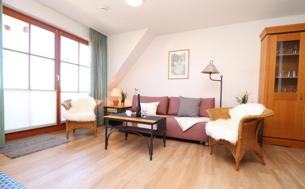 una sala de estar con un sofá y una mesa en Oewern Diek App 06, en Wustrow