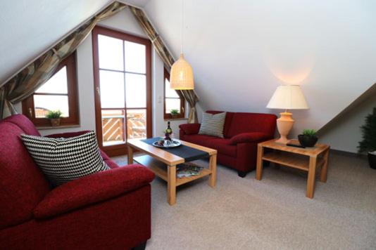 a living room with two red chairs and a table at Oewern Diek App 09 in Wustrow