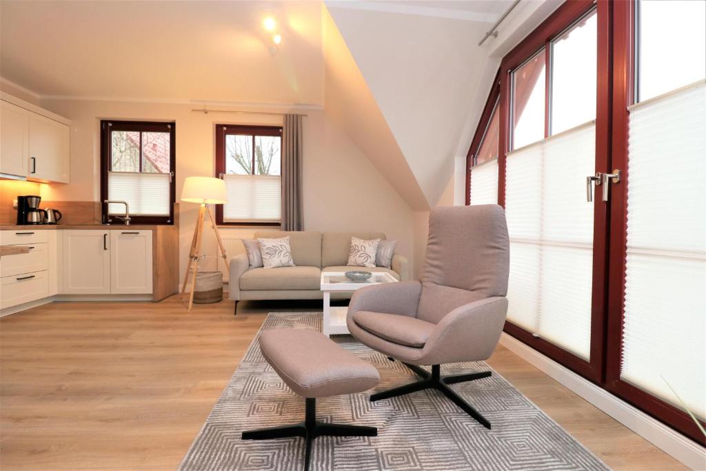 ein Wohnzimmer mit zwei Stühlen und einer Couch in der Unterkunft Oewern Diek App 58 in Wustrow
