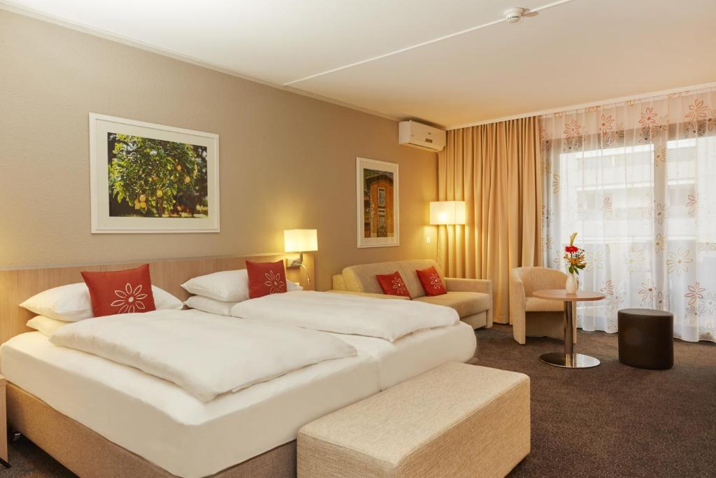 Postel nebo postele na pokoji v ubytování H4 Hotel Arcadia Locarno